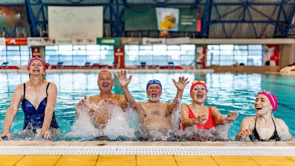 Adults participating in water resistance training and aquatic fitness exercises in a swimming pool